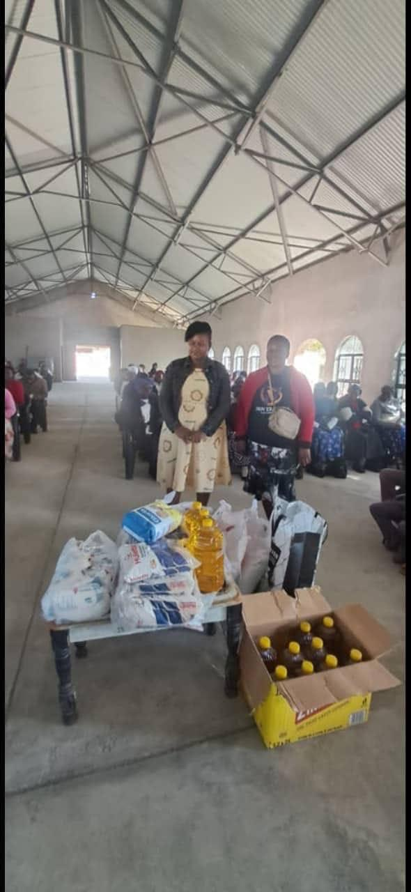 NEF members distributing groceries inside a community hall